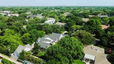 Dallas merkezli iki katlı lüks malikanelerin metal ve kiremitli çatıları var. Arka plan Dallas merkezli, Preston Hollow 'un zengin mahallelerinde yemyeşil ağaçlar, olgun manzaralar. ABD
