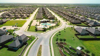 Princeton, Collin County, Teksas 'taki yeni inşaat evlerinin girişinde Amerikan bayrak direği gururla sergileniyor. Toplum havuzu, gölgeli oyun alanı, eğlence tesisleri, iki katlı evler. ABD
