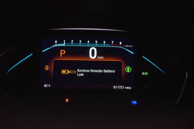 Otoparktaki modern minivan arabasının aydınlatma panelinde anahtarsız uzaktan kumandalı pil düşük uyarı göstergesi, potansiyel sorun göstergesi ışıkları, araç durumu, pil gücü azalan anahtarlık. ABD