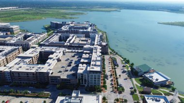 Modern apartman avlusunun yanındaki rıhtım restoranının göl kıyısındaki terası Cypress Waters banliyösü Dallas Fort Worth metroplex, Teksas 'ta büyük planlanmış garajın otoparkı. ABD