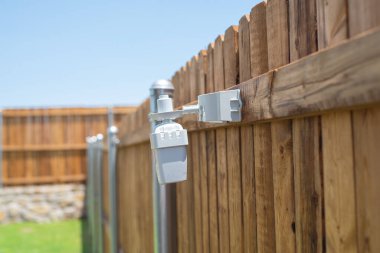 Dallas, Teksas yakınlarındaki yeni inşaat evinin arka bahçesinde kablosuz yağmurlu ve dondurucu sensörlü duvar çitleri olan taş, yağmur veya donma anında sulama sistemini kapatıyor. ABD