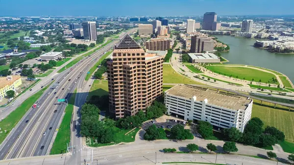 Yoğun Teksas Eyalet Otoyolu SH 114, John Carpenter Otoyolu, Las Colinas şehir merkezi Irving 'deki büyük şehir merkezi, yüksek katlı cam ofis binaları, göl kenarı apartmanları, konut evleri, golf sahaları. ABD