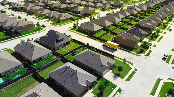 Park etmiş arabaların olduğu yerleşim yerlerinin kesiştiği yer modern tek aile evlerinin olduğu sıra sıra genç ağaçlar ana yerleşim yeri Myrick Lane, Princeton, Teksas 'taki çimlerin peyzajını yapıyor. ABD