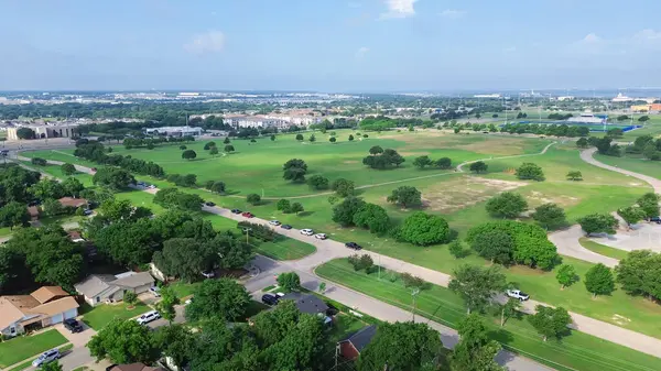 Şehir parkı patikası ve geniş çayırlık Mountain View Park, Güney Dallas, Teksas 'taki Cockrell Hill mahallesi, yemyeşil ağaçlar arasında tek kişilik orta sınıf evler Knoxville Caddesi' nde. ABD