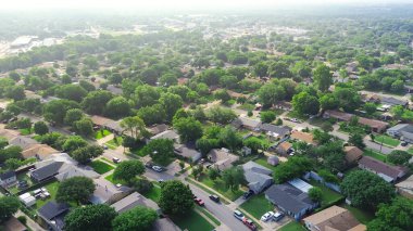 Güney Dallas, Teksas 'taki Cockrell Hill kentsel alanı, arka planda konut alanı ve ticari binalar, park halindeki arabaları ağaçlık sokak boyunca olan orta sınıf tek aile evleri. ABD