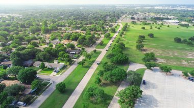 Şehir parkı patikası ve geniş çayırlık Mountain View Park, Güney Dallas, Teksas 'taki Cockrell Hill mahallesi, yemyeşil ağaçlar arasında tek kişilik orta sınıf evler Knoxville Caddesi' nde. ABD