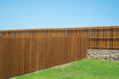 Duvar temeli ve ahşap çit, doğal dış ahşap leke, Princeton, Teksas 'taki yeni inşaat evinin yuvarlak çit kaplama destesi, arka bahçe mahremiyeti. ABD