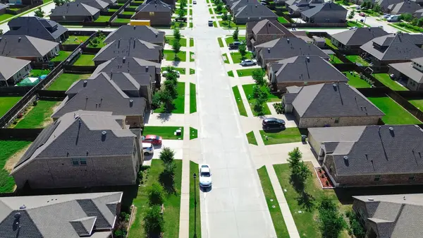 Yeni inşa edilen büyük konutlar, park edilmiş arabalar, modern tek aile evleri boyunca, genç ağaçlar, ana yerleşim yeri Myrick Lane, Princeton, Texas 'ta, olgunlaşmamış peyzaj. ABD