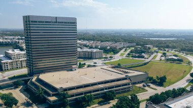Riverside apartmanı, modern cam ofis binası, çok katlı otopark, Las Colinas, Irving 'deki nehir kenarı şirket kampüsü, Dallas Fort Worth iş alanı reklamları. ABD
