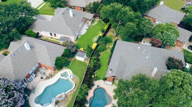 Spacious fenced backyard well maintained fenced grass, resort style swimming pool, patio furniture, open lawn space designed for family recreation and outdoor relaxation in Flower Mound, Texas. US