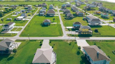 Düşük yoğunluklu, geniş çimenli arka bahçeler tarafından ayrılmış, Teksas 'ın Bolivar limanındaki kumlu sahil şeridine yakın boş bir arazi. ABD