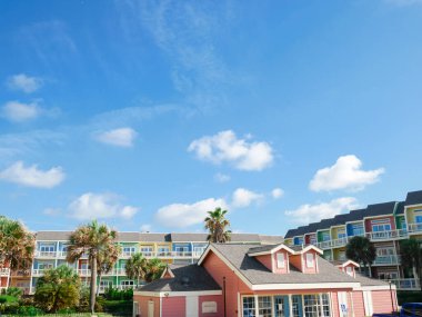 Kiralama merkezi topluluk hoş geldin merkezi. Arkasında renkli evler var. Palmiye ağaçları ve mavi gökyüzü bu canlı Galveston Körfezi topluluğunu resmediyor. Gayrimenkul ve tatil temaları için ideal. ABD