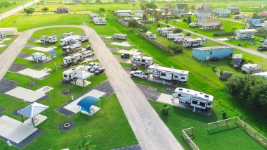 Teksas, Port Bolivar 'da yükseltilmiş sahil evleri ve yakınlarda karavanlar. Durgun mimari, çitli bahçeler ve çakıl yolları Galveston yakınlarındaki sakin bir sahil bölgesinde sele dayanıklı tasarımı yansıtıyor. ABD