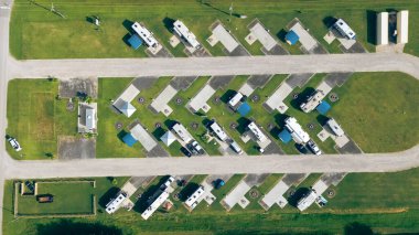 Texas, Port Bolivar 'daki U-şekilli karavan parkının tepeden aşağı görüntüsü. Geniş beton bloknotlar ve mavi çatılı sığınaklar. Kıyı planlama ve uzun vadeli karavanlar için altyapıyı gösteriyor. ABD