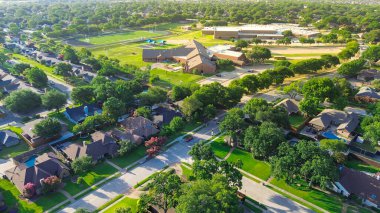 Coppell ISD 'nin üst düzey okul kampüsünün hava görüntüsü, Teksas' ın banliyö evleri ve yeşillikleriyle çevrili iki tane illik ve ortaokul binası, oyun alanı ve spor alanlarını gösteriyor. ABD
