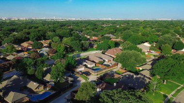 Coppell yerleşim alanının yüksek manzaralı, ağaçlarla kaplı caddeleri ve yüksek gökdelenlerin, su kulesinin ve Cypress Waters şirket kampüsünün uzak siluetine kurulmuş lüks evleri var. ABD