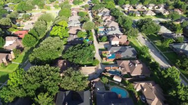 İyi planlanmış Coppell, Teksas 'ın arka sokaklarında, çatıları perdeli, aile evleri, ağaçlarla çevrili, ağaçlarla çevrili, çevreye duyarlı banliyöleri yansıtan ağaçlar.