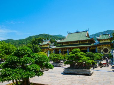 Linh Ung Pagoda 'daki geleneksel Vietnam tapınağı avlusunda ters dönmüş saçaklar, ejderha motifleri, canlı çatı kiremitleri, büyük taş ekicilerindeki bonsai ağaçları ve Danang' daki dekoratif mimari yer alıyor. Vietnam