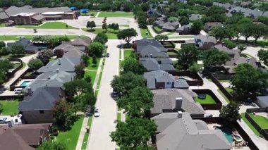 Elevated view of tree-lined residential street in Coppell, Texas with large two-story homes, fenced backyards, swimming pools, and sidewalks leading directly to Cottonwood Creek Elementary School