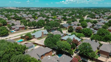 Downtown Plano Texas background with residential neighborhood in Coppell, Texas, mature trees, fenced yards, swimming pools, upscale two-story homes in master planned community in suburbs Dallas. USA