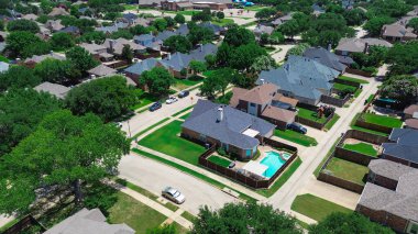 Row of large suburban homes in Coppell, Texas with fenced yards, swimming pools, mature trees, located near Cottonwood Elementary School in a walkable, master-planned community suburbs Dallas. USA