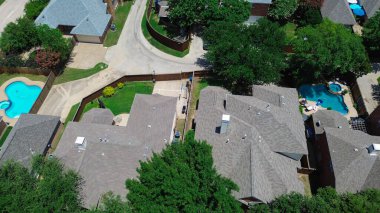 Coppell, Teksas 'ta iki katlı büyük banliyö evi gri kiremit çatıları, çitli arka bahçesi, dairesel yüzme havuzu, teras mobilyası, olgun ağaçlar, arka sokak garajı, Dallas banliyöleri. ABD