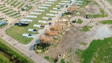 Karavan parkındaki dairesel cadde ve Texas 'ın Bolivar Yarımadası yakınlarında kereste, çöp konteynırı, yeşil teleskopik kontrol makineleri ile inşa edilmiş kereste stiği olan kiralık evler. ABD