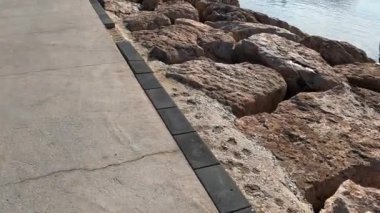 An old fisherman with a beard on the coast catches fish