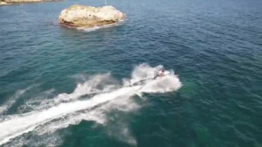 Güneşli bir günde tropikal mavi suda jet ski süren bir adam. Havadan. Yüksek kalite 4k görüntü