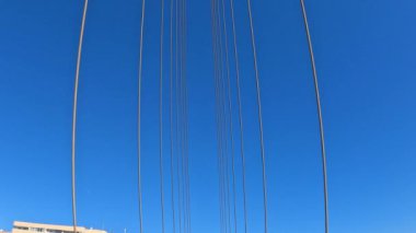 Mavi gökyüzü ve güneş ışığına karşı çelik halatlarla asma köprü desteği. Modern mühendislik yapıları kavramı. Yüksek kalite 4k görüntü