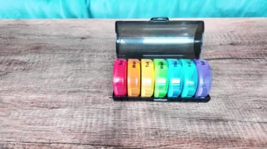 Haftanın her günü siyah kalemli haplar için plastik organizatör kutusu. Geleneksel ve alternatif tıp ve sağlık, hastalık, salgın, covid-19 konsepti. Yüksek kalite 4k görüntü
