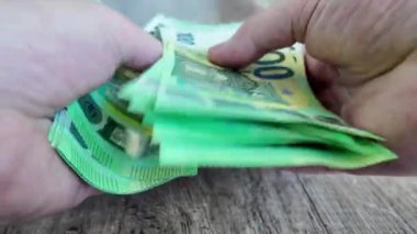 Bir adam 100 avroluk banknotları sayıp teker teker yerleştiriyor. Yüksek kalite 4k görüntü