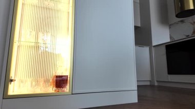 Gri mobilyaları ve altın bir lavabosu olan modern, lüks bir mutfak. Yüksek kalite 4k görüntü