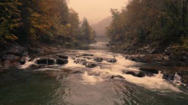 Muhteşem sonbahar dağ manzarası. Şelalesi çağlayan bir nehir..
