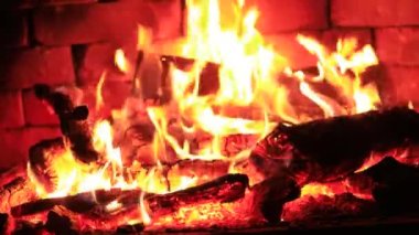 Şöminede odun yanıyor, arka planda alevler..