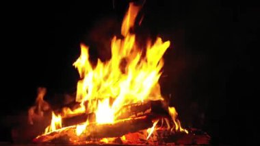 Şöminede odun yanıyor, arka planda alevler..
