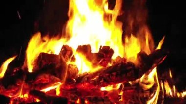 Şöminede odun yanıyor, arka planda alevler..