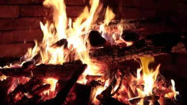 Şöminede odun yanıyor, arka planda alevler..
