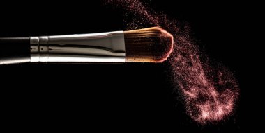 makeup brushes and powder on a black background. Freezing