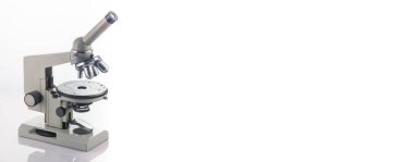 A microscope with three lenses on a white background. Concept, research science and medicine.