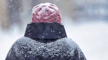 Man outdoors in winter clothes during blizzard and heavy snowfall. Deterioration of weather conditions. concept