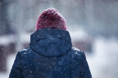 Man outdoors in winter clothes during blizzard and heavy snowfall. Deterioration of weather conditions. concept