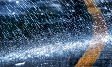 Raindrops fall on the asphalt. Deterioration of weather conditions. Precipitation, cooling.