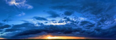 A wonderful sunset. Yellow-orange clouds against the background of the blue sky at dawn. A wonderful natural background.