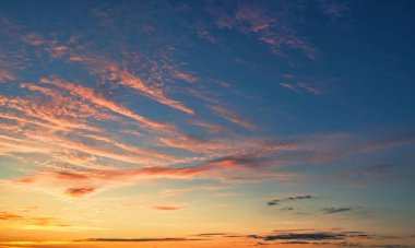 The sky before dawn, orange clouds on the background of the blue sky. Abstract natural background.