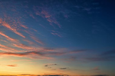 The sky before dawn, orange clouds on the background of the blue sky. Abstract natural background.