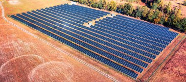 solar power station on a field with scorched grass in the foreground. The solar power station generates clean energy, highlighting the shift towards renewable energy sources and combating the effects of climate change