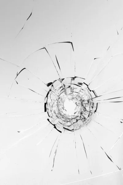 Cracked glass with bullet hole resembling spider web pattern
