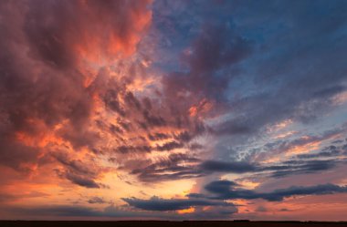 Parlak günbatımının bu nefes kesici görüntüsüyle altın saat. Sıcak renkler ve aydınlık bulutlar sizi başka bir dünyaya taşıyacak sihirli bir parıltı yaratır.