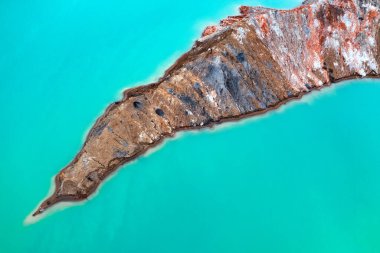 Bu çarpıcı hava görüntüsü bir titanyum madenciliğinin endüstriyel güzelliğini yakalıyor. Renkli sıvı tanklar engebeli araziye karşı çarpıcı bir kontrast sağlıyor.